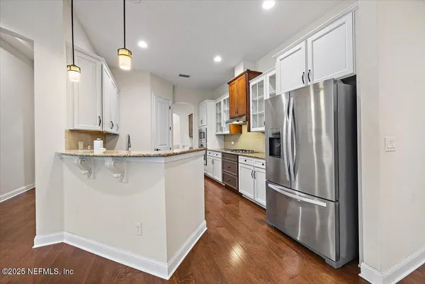 a kitchen with stainless steel appliances a refrigerator and a stove top oven