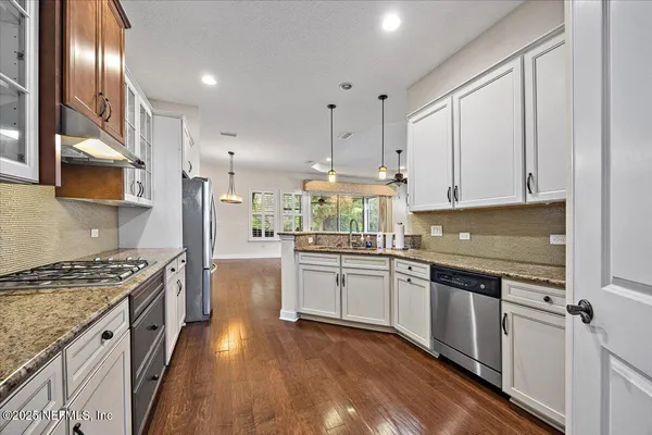 a kitchen with stainless steel appliances granite countertop a stove sink and cabinets