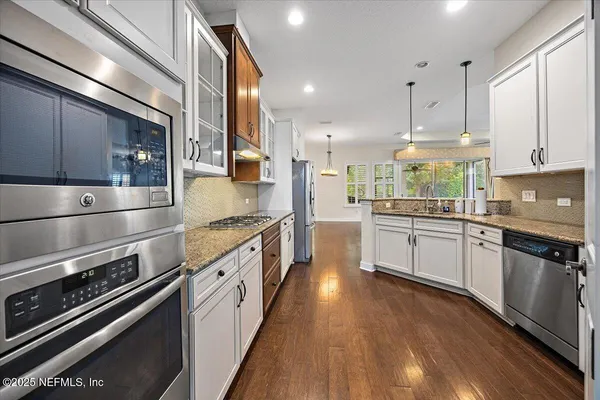 a kitchen with stainless steel appliances and white cabinets