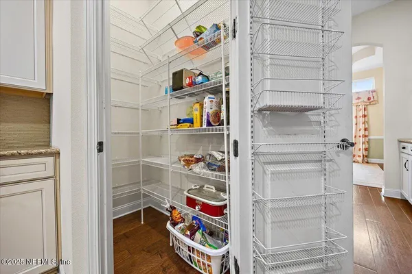 a view of walk in closet with clothes and shoes