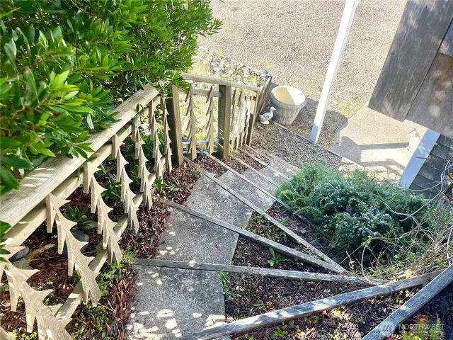 a view of a balcony with wooden floor and iron stairs