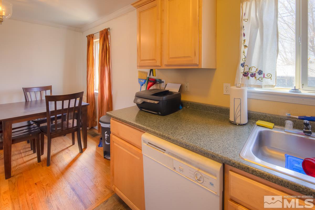895 Cherry Lane Reno, NV 89509 - Photo 7 of 26 a kitchen with a sink a stove and a dining table with wooden floor