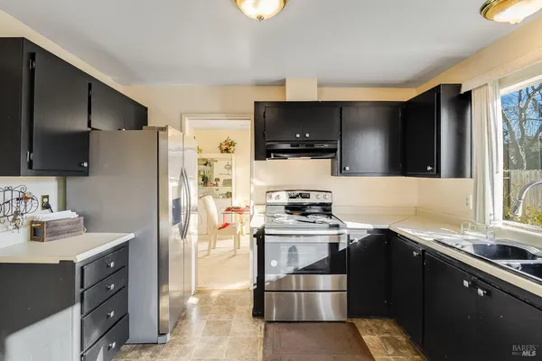 a kitchen with stainless steel appliances a stove sink microwave refrigerator and cabinets