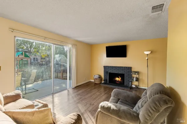 a living room with furniture a fireplace and a floor to ceiling window