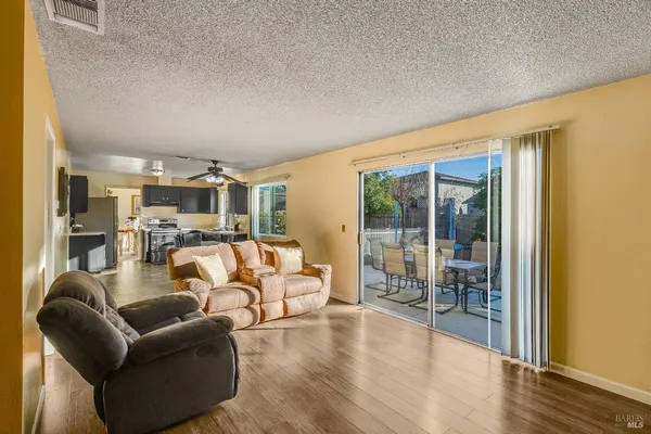 a view of a livingroom with furniture wooden floor and a floor to ceiling window