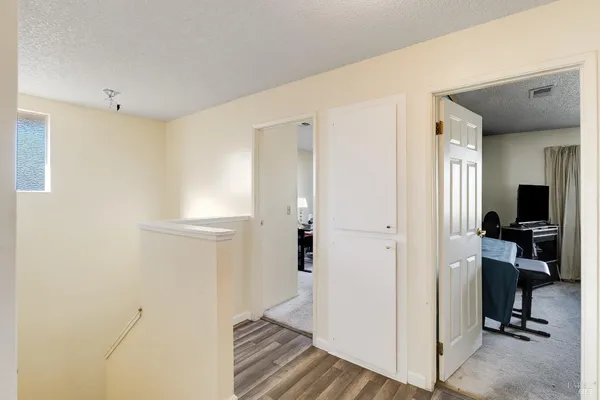 a view of a hallway with bathroom and wooden floor