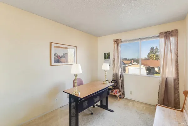 a view of a room with wooden floor and a workspace