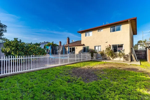 a view of a house with backyard and sitting area