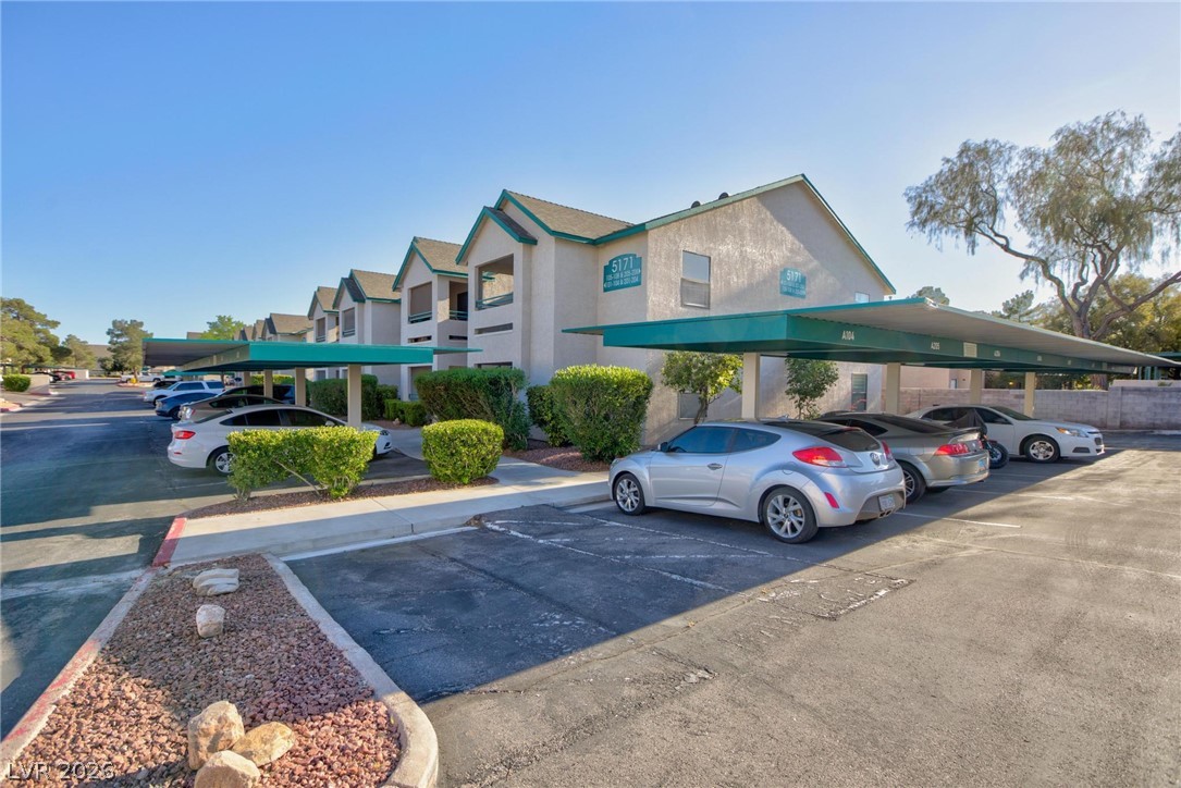 5171 South Lindell Road, Unit 103 Las Vegas, NV 89118 - Photo 19 of 24 Covered parking offers convenience, complementing the inviting exterior of this residential building.