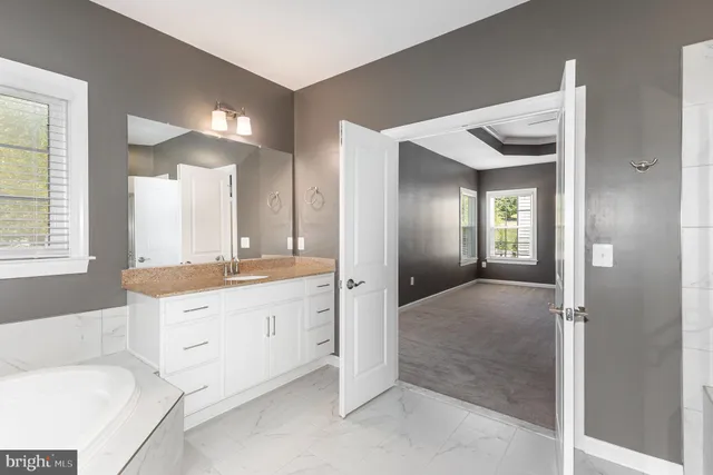 a bathroom with a granite countertop sink and a mirror