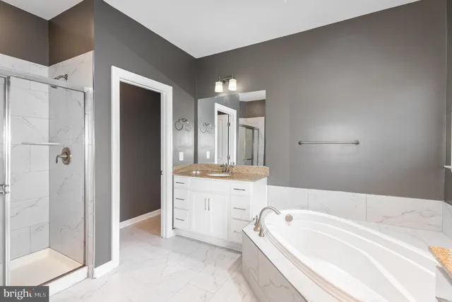 a spacious bathroom with a tub sink shower and mirror