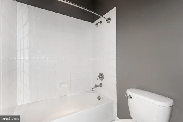 a white toilet sitting next to a bath tub