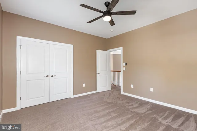 a view of a livingroom with a ceiling fan & entryway