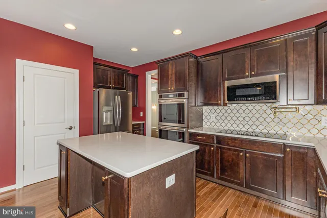 a kitchen with stainless steel appliances a microwave a sink and refrigerator