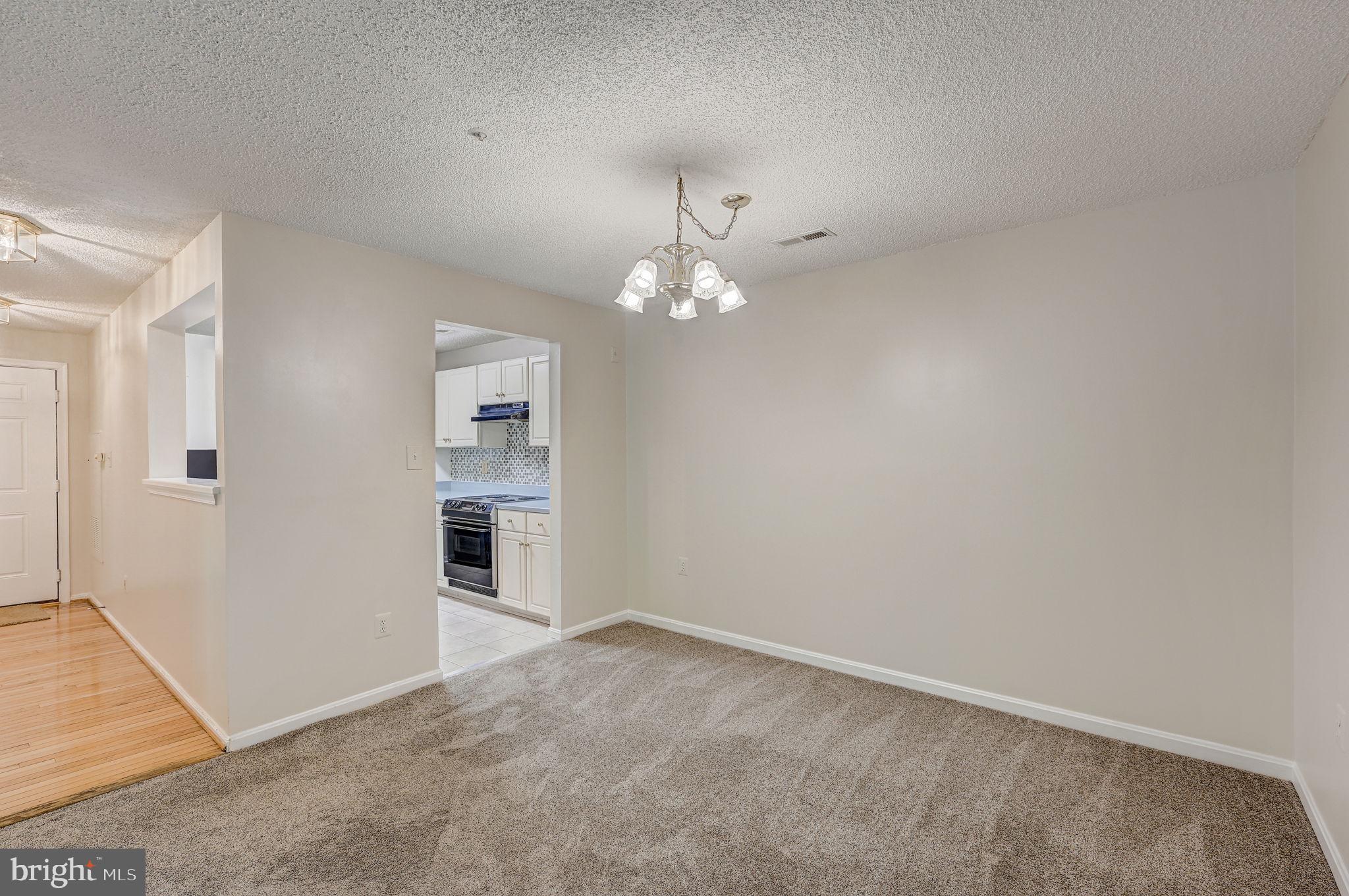 12903 Churchill Ridge Circle, Unit 6 Germantown, MD 20874 - Photo 9 of 36 an empty room with chandelier fan and kitchen view