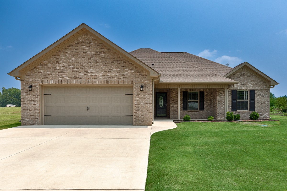 a front view of a house with a garden and yard