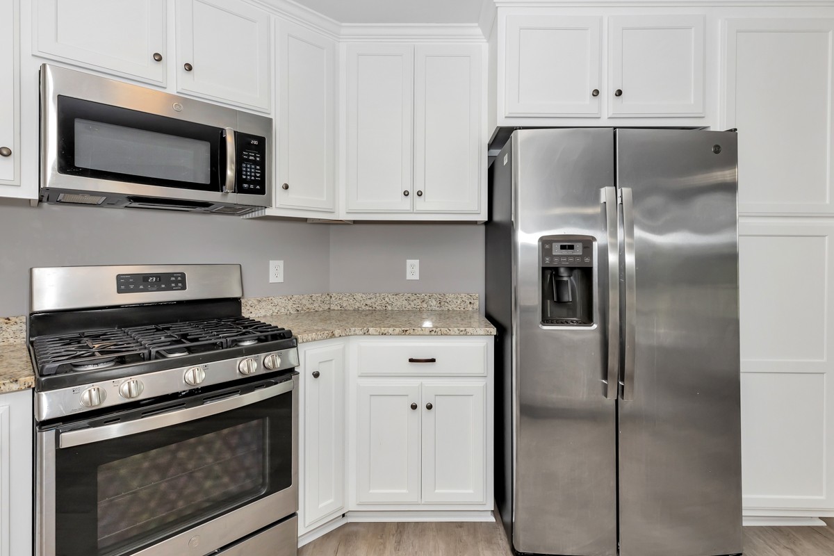 28600 Reyer Road Ardmore, AL 35739 - Photo 8 of 28 a kitchen with stainless steel appliances white cabinets a sink and a microwave
