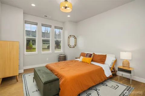 a bedroom with a bed and a lamp next to a window