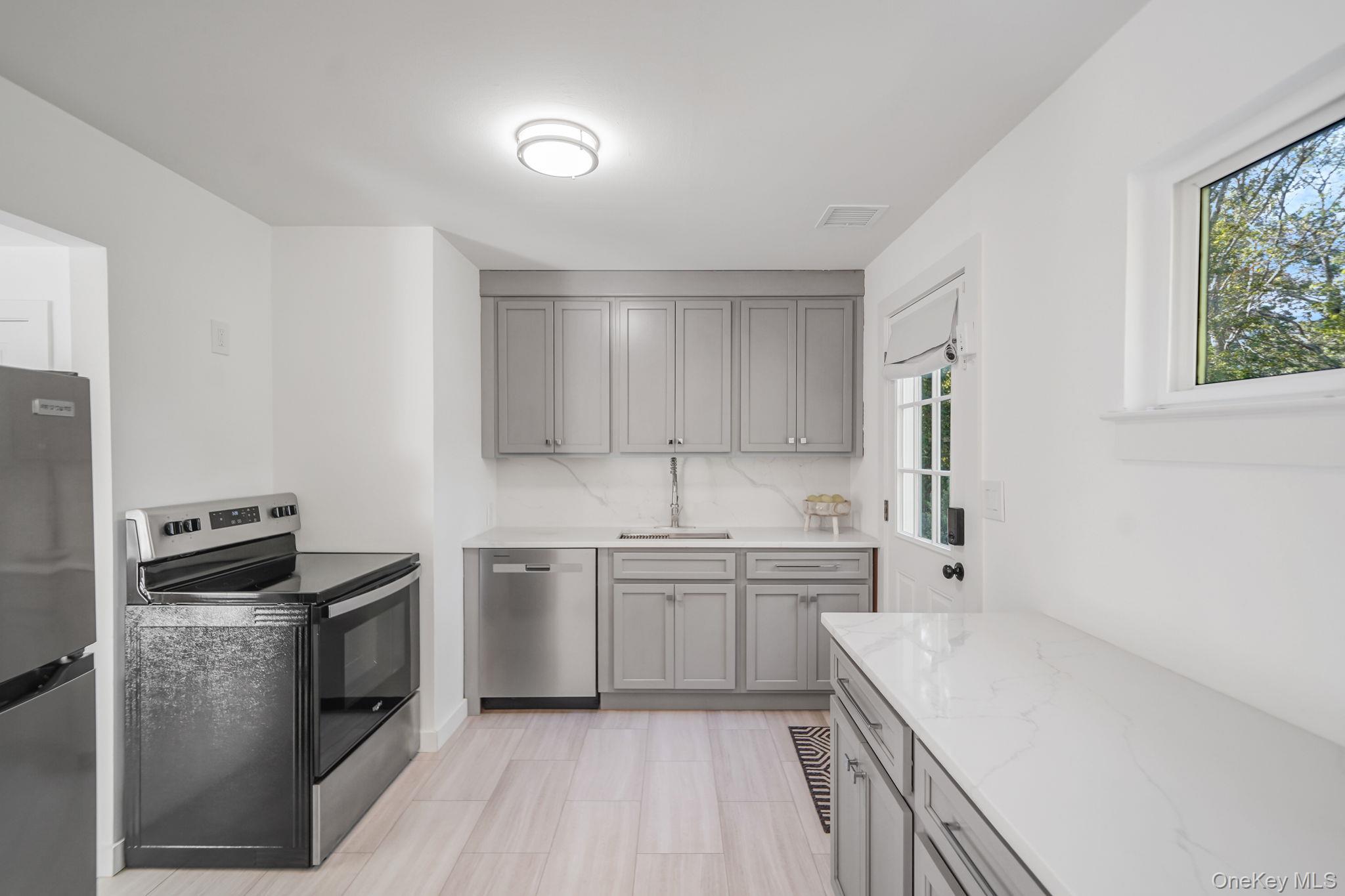 138 West Tiana Road Hampton Bays, NY 11946 - Photo 6 of 24 a kitchen with a sink stove and refrigerator