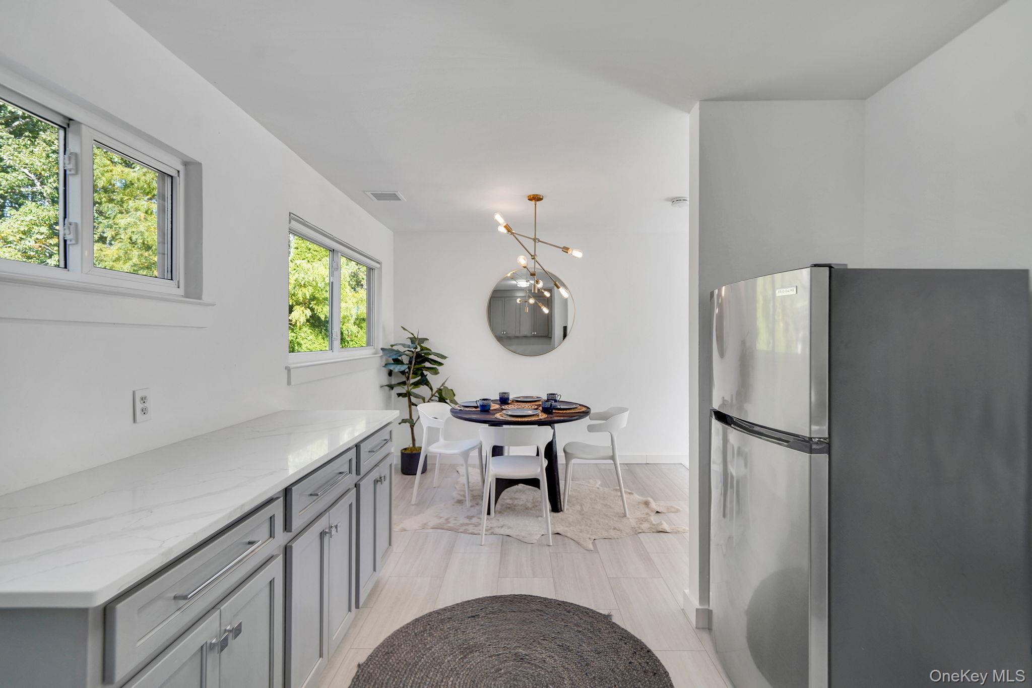 138 West Tiana Road Hampton Bays, NY 11946 - Photo 8 of 24 a kitchen with stainless steel appliances granite countertop a refrigerator a stove and a wooden floors