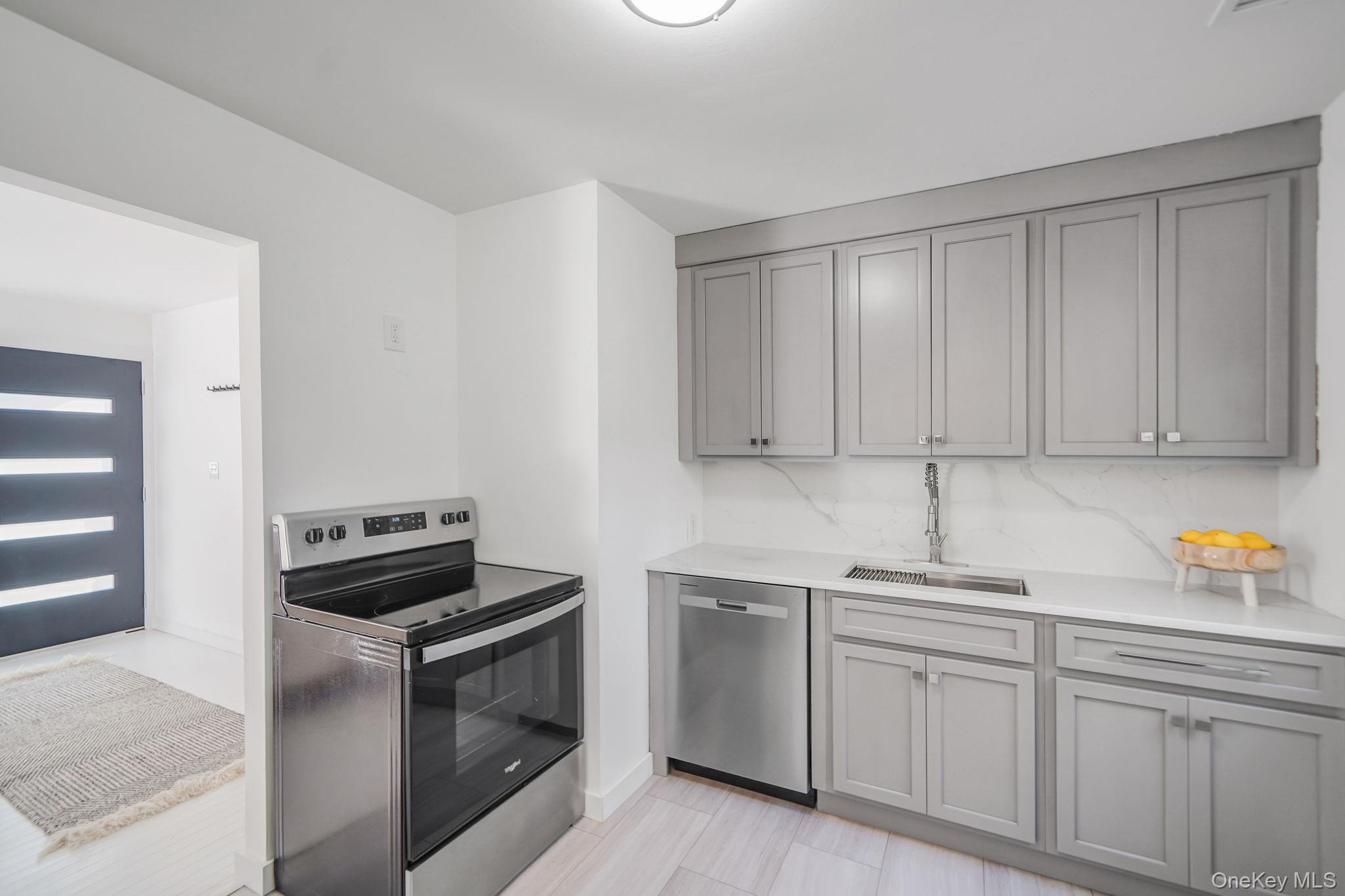 138 West Tiana Road Hampton Bays, NY 11946 - Photo 8 of 24 a kitchen with white cabinets and white appliances