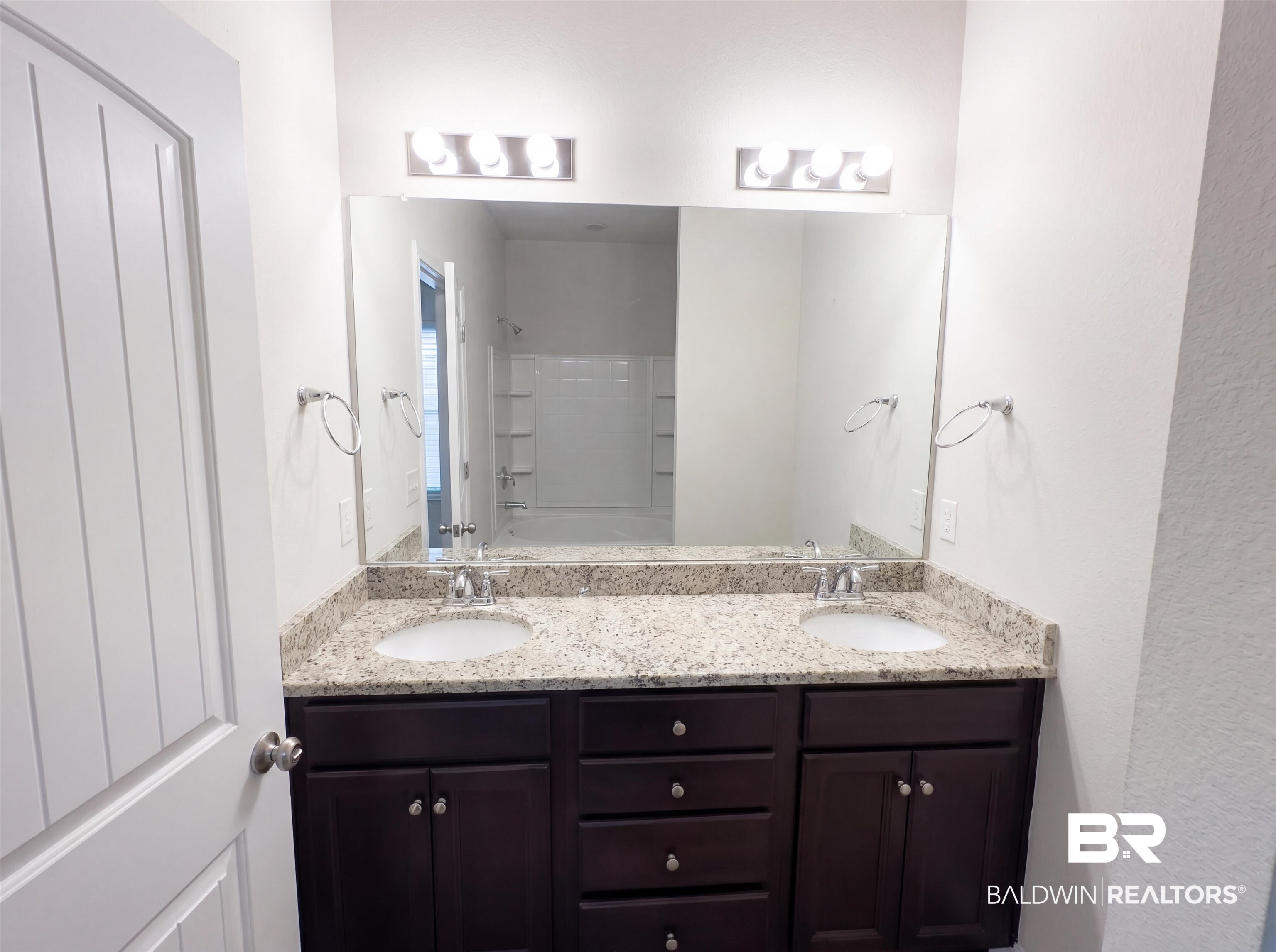 1740 Covington Lane Foley, AL 36535 - Photo 14 of 18 Bathroom featuring a double vanity with stone countertops, undermount sinks, and dark wood cabinetry