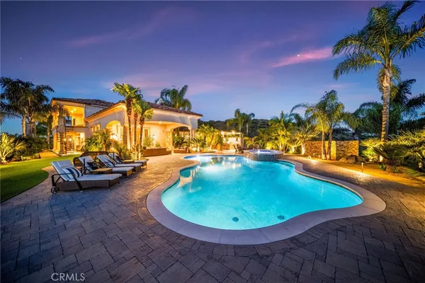 a view of a swimming pool with an outdoor seating a kitchen mountain and swimming pool