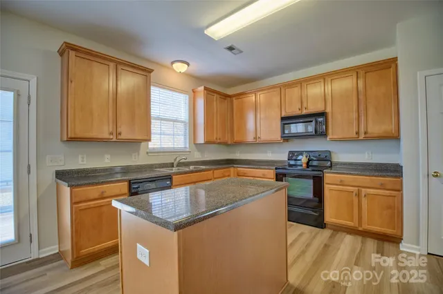 a kitchen with stainless steel appliances granite countertop a sink stove and cabinets