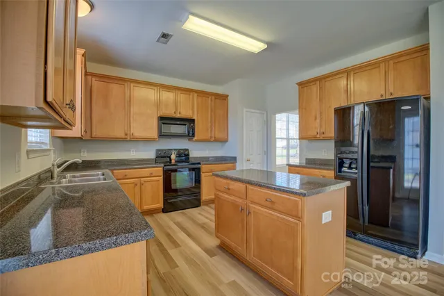a kitchen with stainless steel appliances granite countertop a sink stove and cabinets