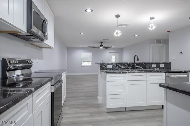 a kitchen with a stove cabinets and wooden floor