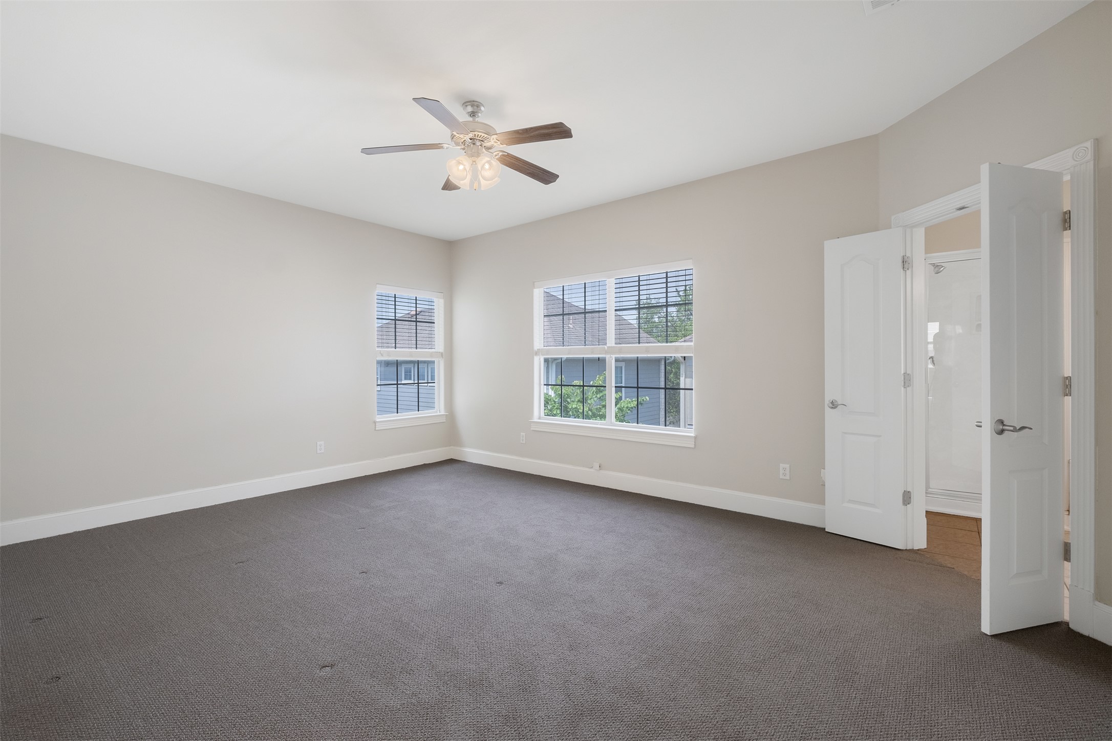 6715 Windrift Way, Unit 8 Austin, TX 78745 - Photo 13 of 24 A spacious bedroom featuring comfortable carpeting and an ensuite bath through double doors.