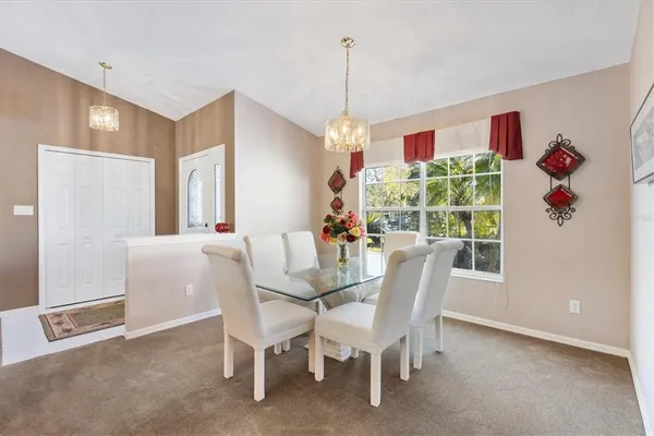 a view of a dining room with furniture and a chandelier