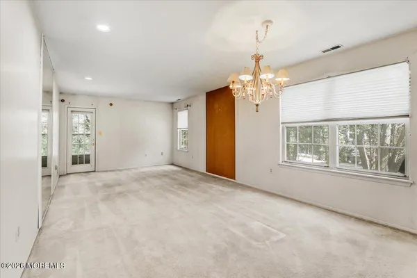 an empty room with chandelier and windows