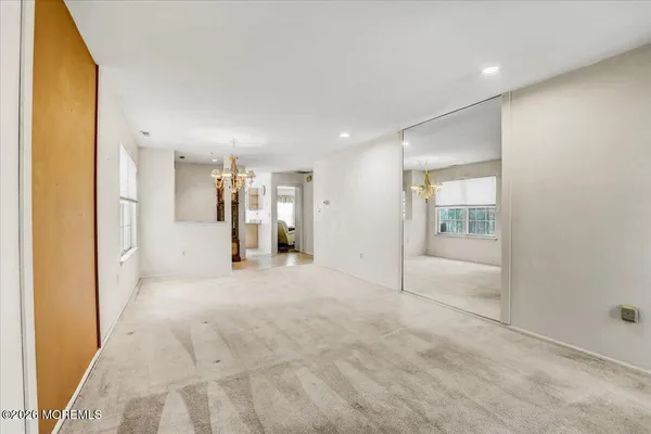 an empty room with a bathroom and windows
