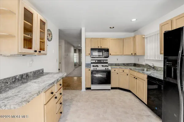 a kitchen with granite countertop a sink stove and refrigerator