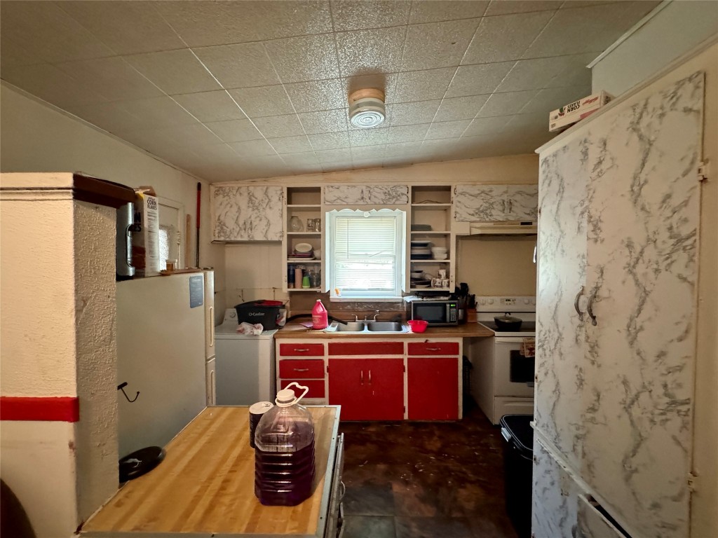 1007 North 17th Street Temple, TX 76501 - Photo 5 of 11 a room with stainless steel appliances kitchen island granite countertop a refrigerator and a stove
