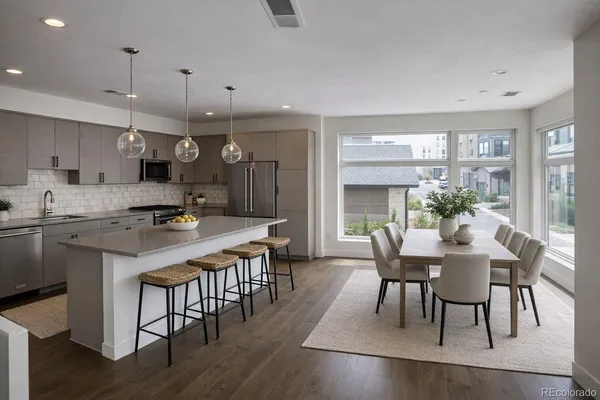 a kitchen with a dining table chairs and white cabinets