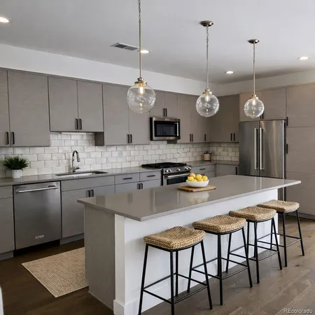 a kitchen with a dining table a sink a counter space and stainless steel appliances