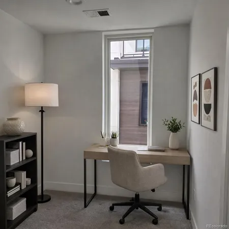 a view of a workspace room with furniture and a window
