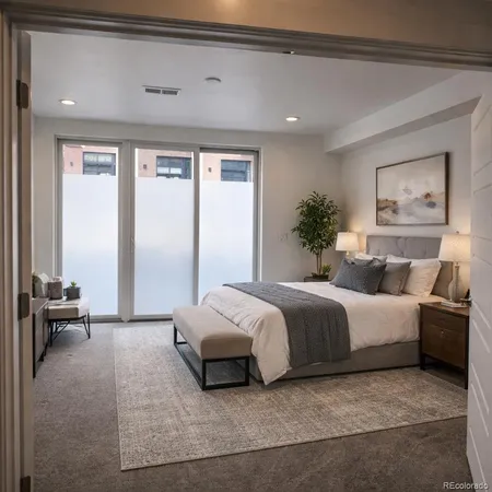 a spacious bedroom with a bed and a large window