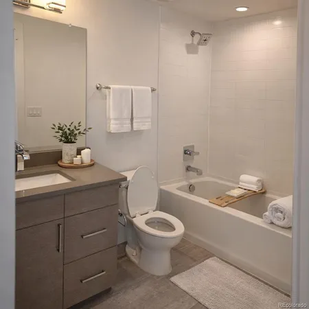 a bathroom with a granite countertop toilet a sink and a bathtub