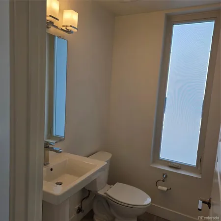 a bathroom with a toilet a sink and mirror