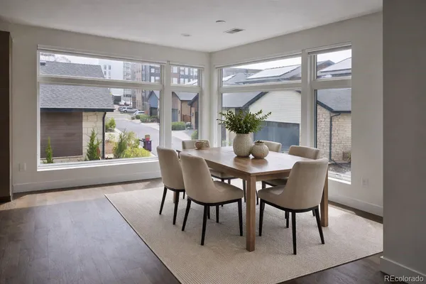 a dining room with furniture window and wooden floor