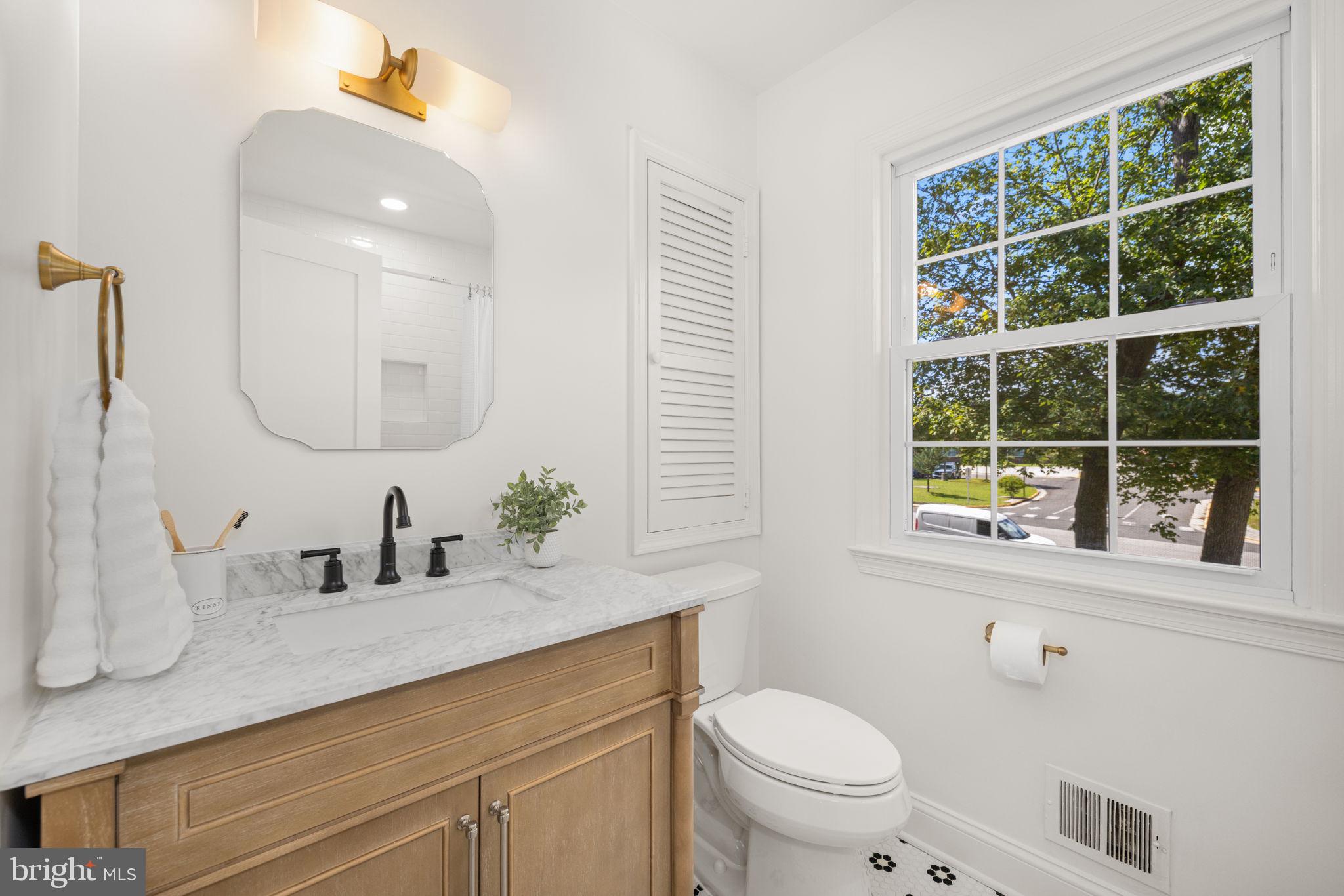 8415 Riverside Road Alexandria, VA 22308 - Photo 23 of 44 a bathroom with a toilet a sink a mirror a window and vanity