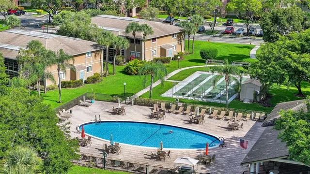 a view of a swimming pool with a yard and plants