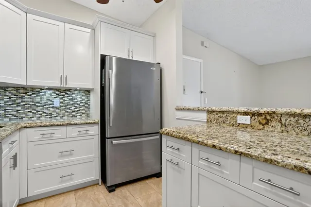 a kitchen with granite countertop cabinets and refrigerator