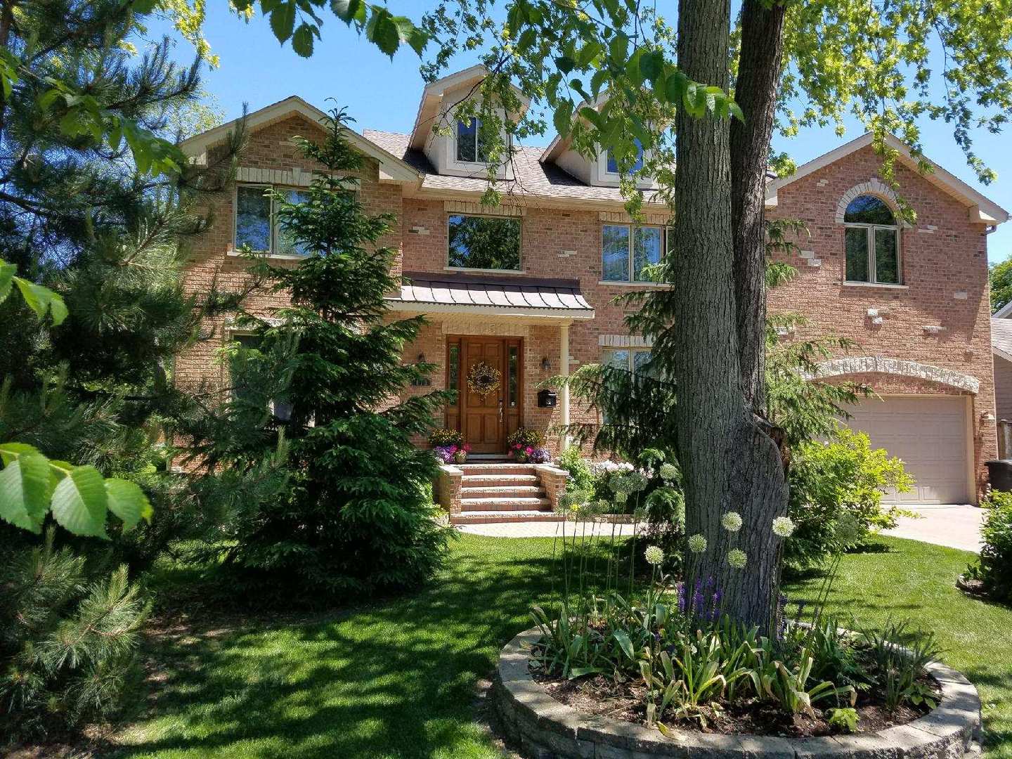 813 Elmdale Road Glenview, IL 60025 - Photo 1 of 26 a front view of a house with a garden