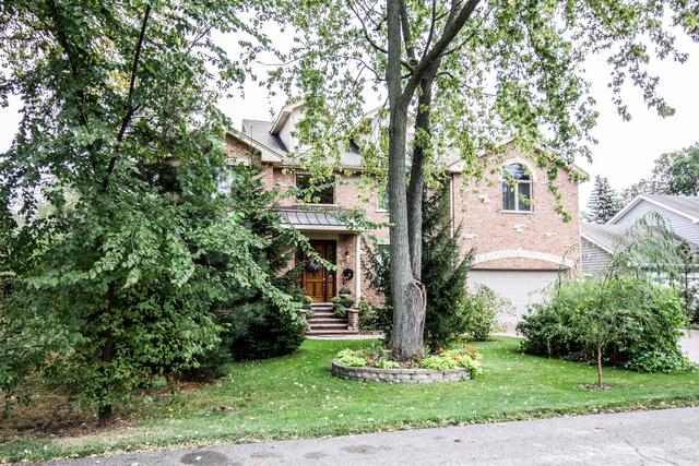813 Elmdale Road Glenview, IL 60025 - Photo 2 of 26 a front view of a house with garden