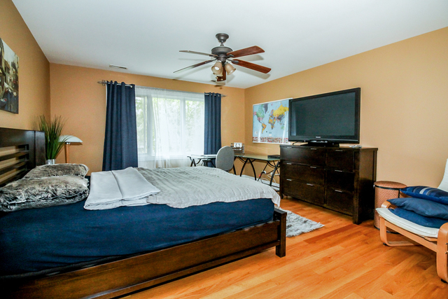 813 Elmdale Road Glenview, IL 60025 - Photo 18 of 26 a bedroom with a bed and a flat screen tv
