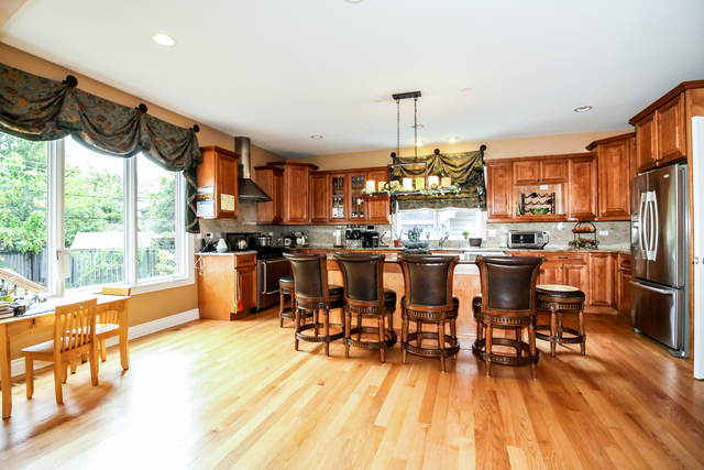 813 Elmdale Road Glenview, IL 60025 - Photo 4 of 26 a kitchen with stainless steel appliances wooden floor dining table and chairs